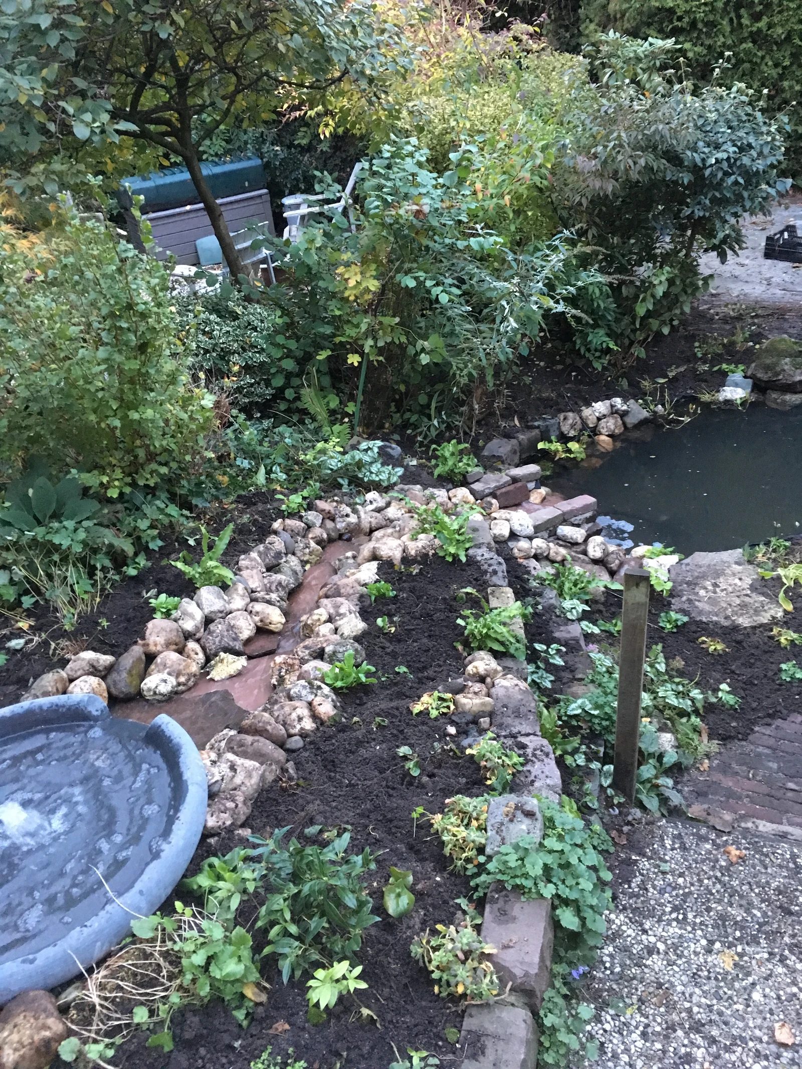 Een foto van een waterstroompje door een tuin heen.