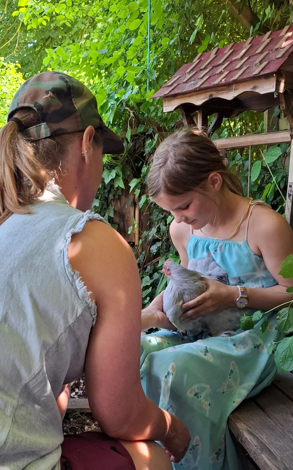 Een foto van Mirjam met een meisje die een kippetje vasthoudt.